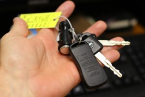 Expert en batterie automobile intervenant avec des clés de voiture lors d’un dépannage